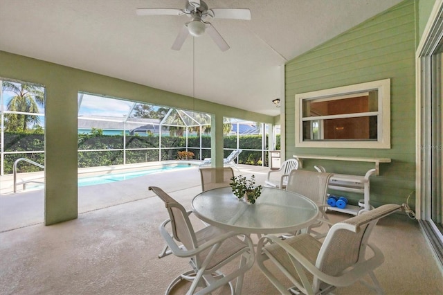 sunroom featuring a wealth of natural light, ceiling fan, vaulted ceiling, and a pool