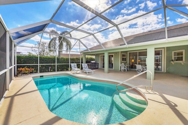 view of pool featuring glass enclosure and a patio