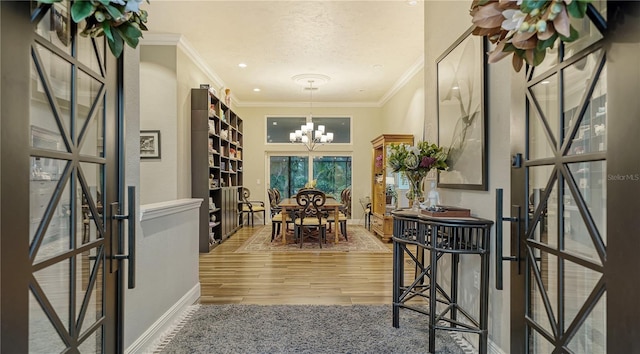 dining space featuring hardwood / wood-style flooring, crown molding, and a notable chandelier