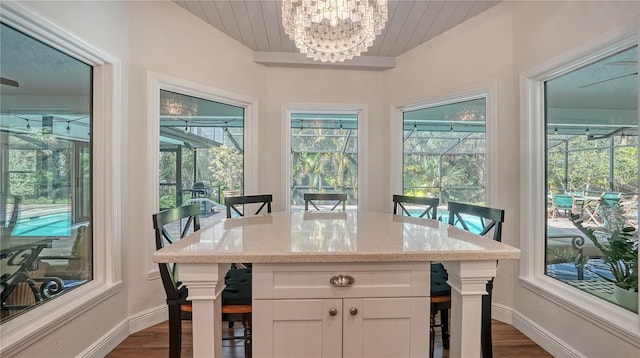 interior space featuring white cabinets, dark hardwood / wood-style floors, light stone countertops, and a healthy amount of sunlight