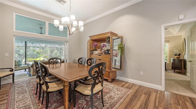 dining room featuring hardwood / wood-style floors, ornamental molding, and an inviting chandelier