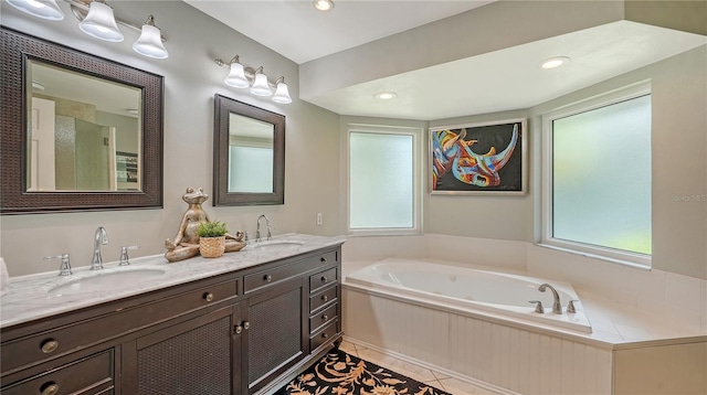 bathroom featuring tile patterned flooring, vanity, and a tub