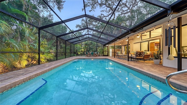 view of pool featuring an outdoor living space, a patio area, ceiling fan, and a lanai