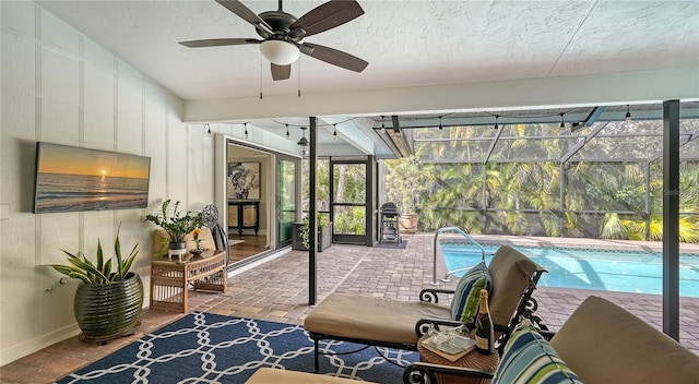 sunroom with ceiling fan, a swimming pool, and lofted ceiling