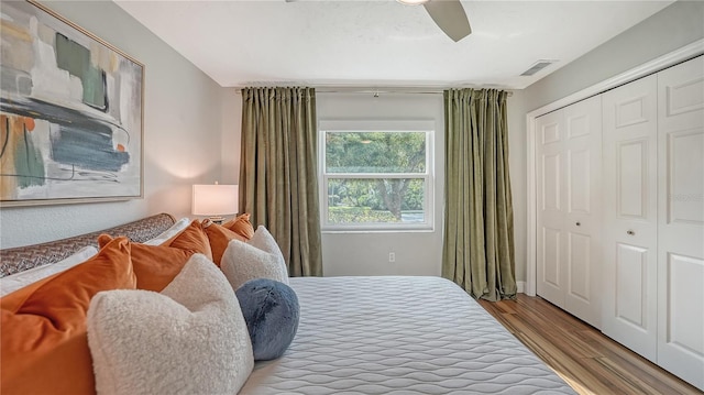 bedroom with light hardwood / wood-style floors, a closet, and ceiling fan