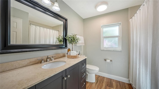 bathroom with hardwood / wood-style floors, vanity, and toilet