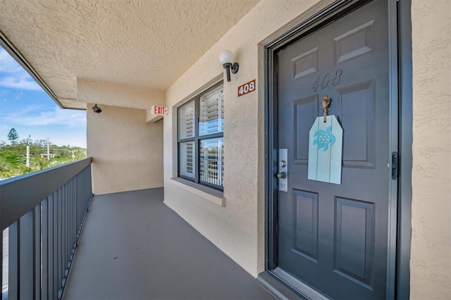 view of exterior entry with a balcony