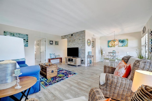 living room with light wood-type flooring and an inviting chandelier