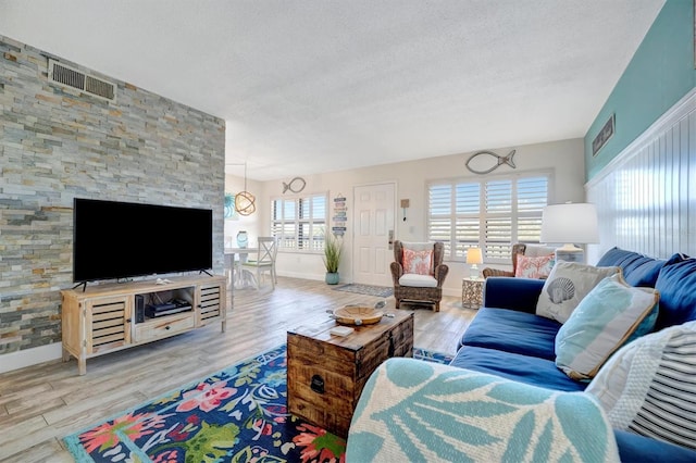 living room featuring a textured ceiling and light hardwood / wood-style flooring