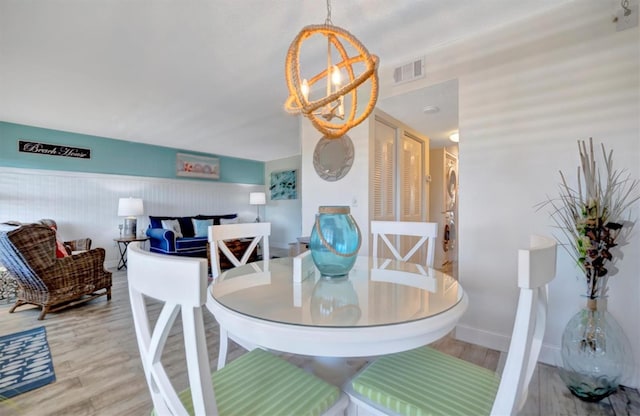 dining space with a chandelier and light wood-type flooring