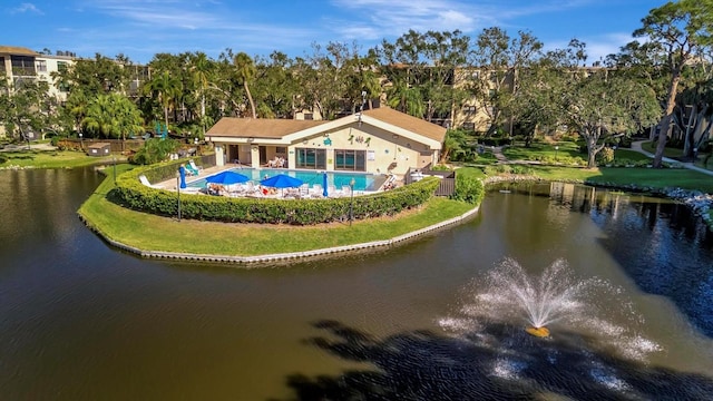 back of house with a lawn and a water view