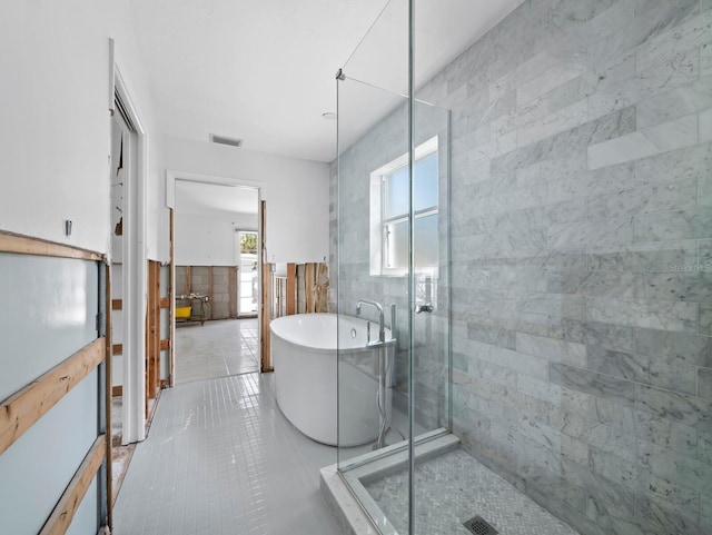 611 Hibiscus Way, Longboat Key, FL 34228 - bathroom featuring tile patterned floors, wainscoting, a freestanding bath, tile walls, and a stall shower