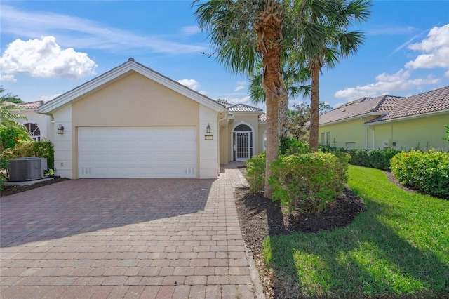 view of front of property featuring a garage and central air condition unit