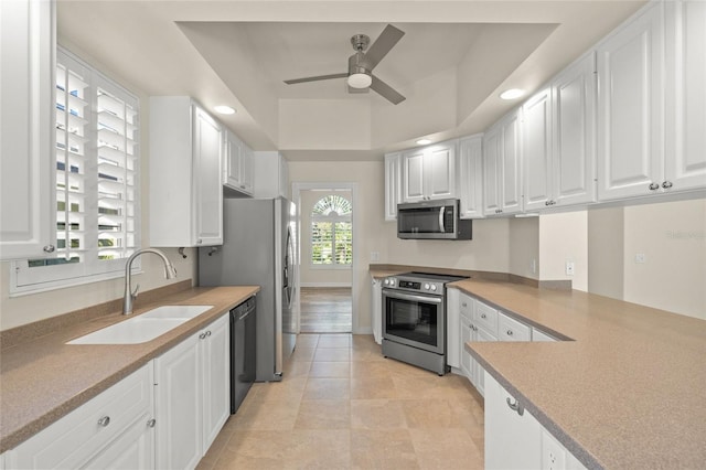 kitchen with white cabinets, appliances with stainless steel finishes, ceiling fan, and sink