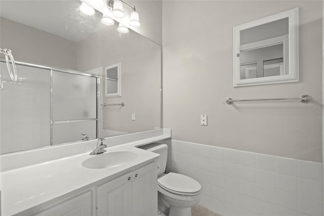 bathroom featuring vanity, toilet, and an enclosed shower