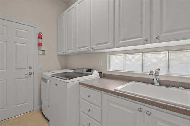 laundry area featuring cabinets, washing machine and dryer, and sink