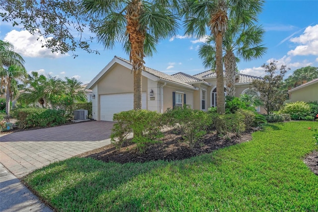 view of front of property featuring a garage, central air condition unit, and a front lawn