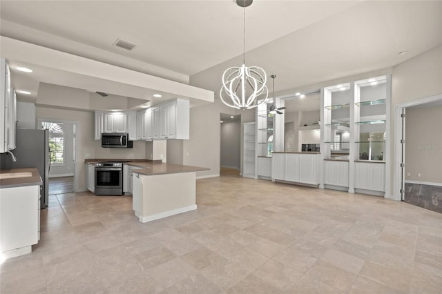 kitchen with kitchen peninsula, appliances with stainless steel finishes, pendant lighting, an inviting chandelier, and white cabinetry