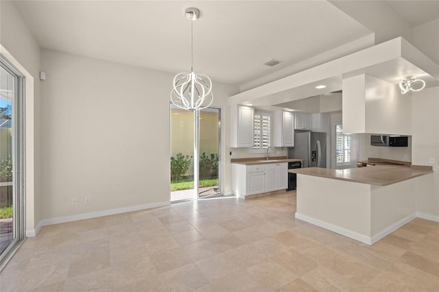 kitchen featuring white cabinets, stainless steel appliances, kitchen peninsula, and plenty of natural light