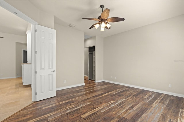 unfurnished bedroom with a closet, dark hardwood / wood-style floors, and ceiling fan