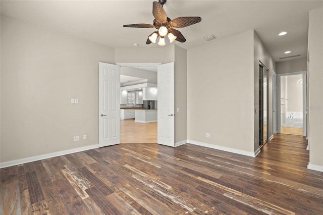 spare room with dark hardwood / wood-style flooring and ceiling fan