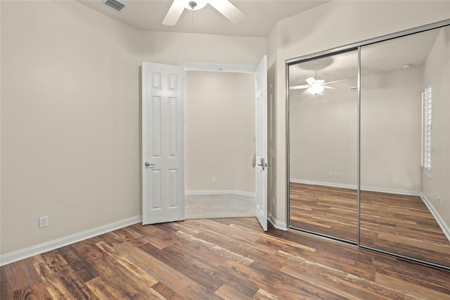 unfurnished bedroom with hardwood / wood-style flooring, ceiling fan, and a closet