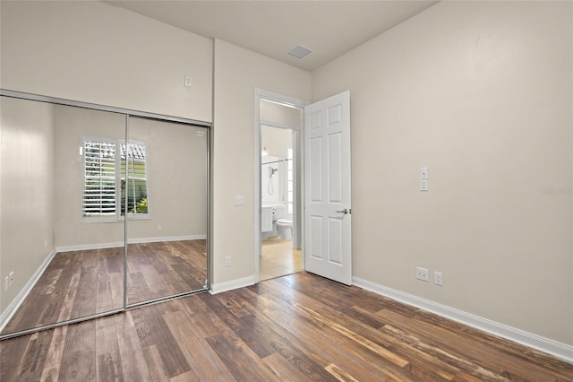 unfurnished bedroom featuring a closet and dark hardwood / wood-style flooring