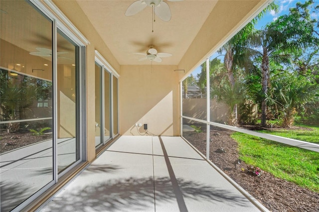 unfurnished sunroom featuring ceiling fan