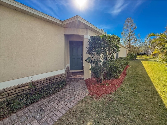 doorway to property with a lawn