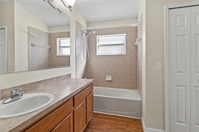 bathroom featuring hardwood / wood-style floors, vanity, and tiled shower / bath