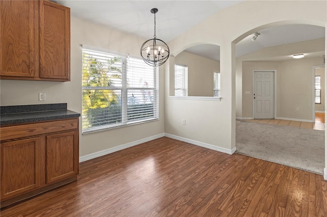 unfurnished dining area featuring a chandelier and dark hardwood / wood-style floors