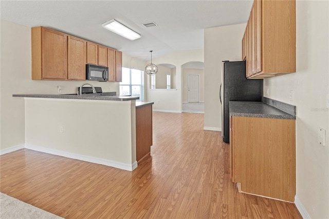 kitchen with pendant lighting, light wood-type flooring, kitchen peninsula, and fridge