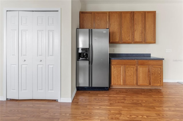 kitchen with hardwood / wood-style flooring and stainless steel fridge with ice dispenser