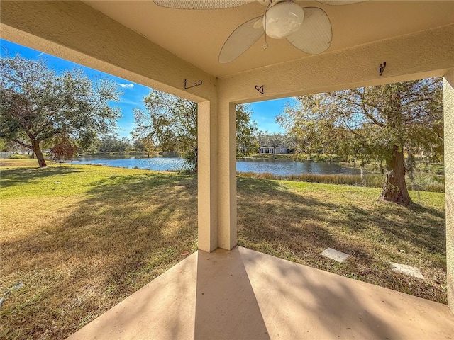 view of patio with ceiling fan and a water view