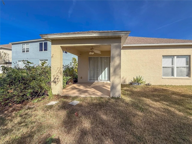 back of property featuring a lawn, ceiling fan, and a patio