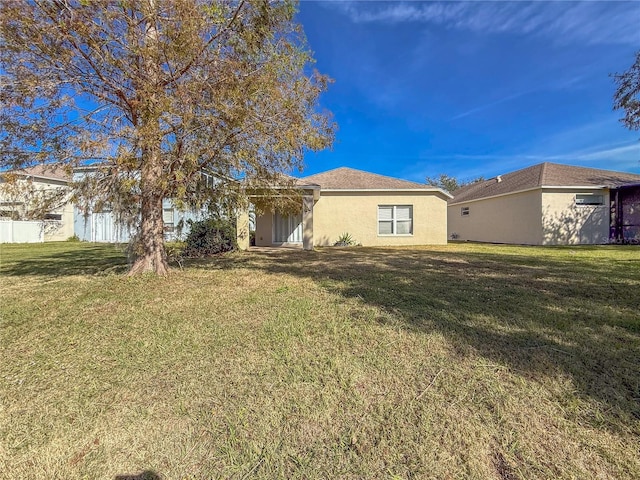 rear view of house featuring a yard