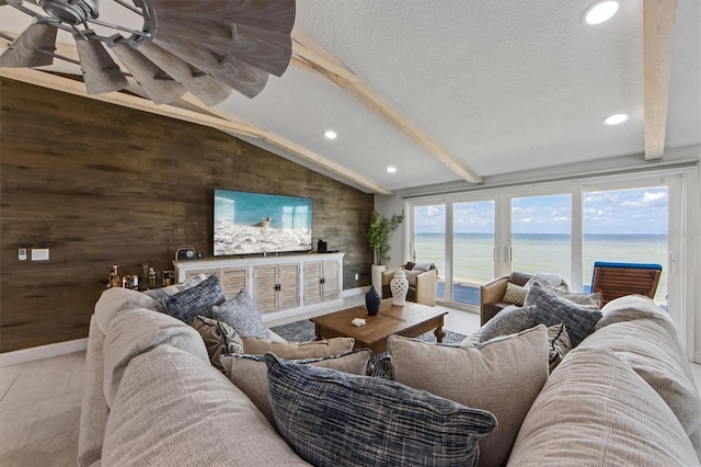 living room featuring a textured ceiling, lofted ceiling with beams, wooden walls, and light tile patterned flooring