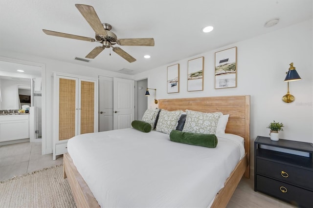 tiled bedroom featuring connected bathroom and ceiling fan