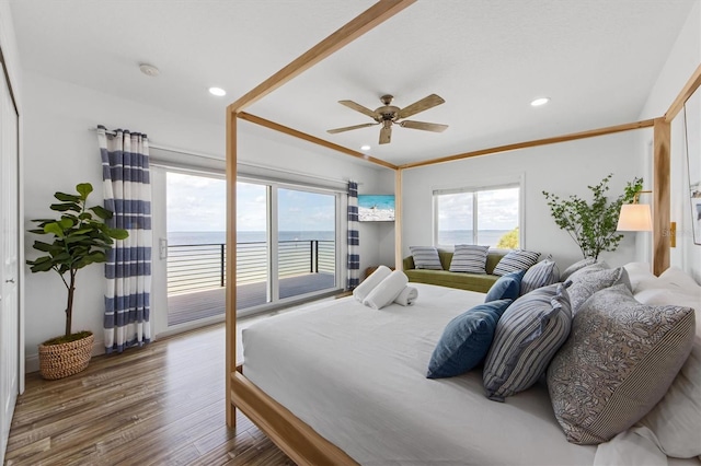 bedroom featuring access to exterior, ceiling fan, crown molding, hardwood / wood-style floors, and a water view