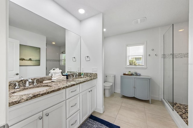 bathroom featuring a tile shower, tile patterned floors, vanity, and toilet