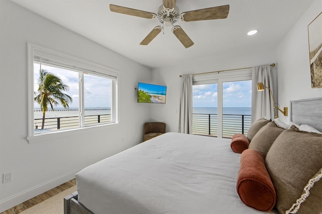 bedroom featuring multiple windows, hardwood / wood-style floors, and ceiling fan