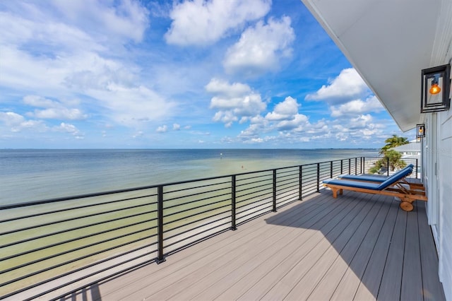 wooden deck with a water view and a view of the beach