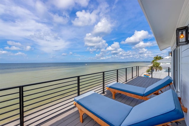 balcony featuring a water view and a beach view