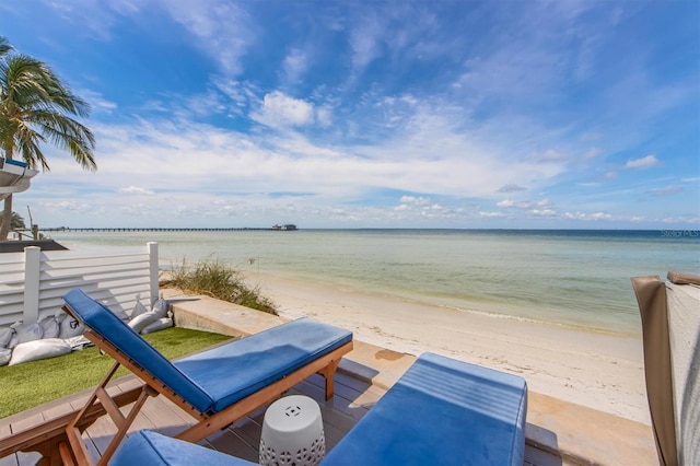 view of patio / terrace with a water view and a beach view