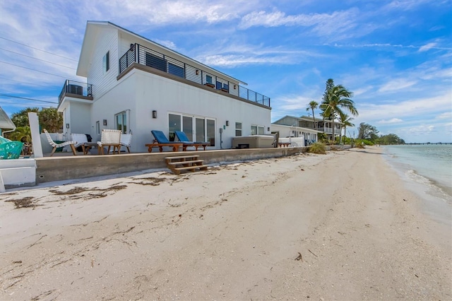 exterior space featuring a water view and a beach view