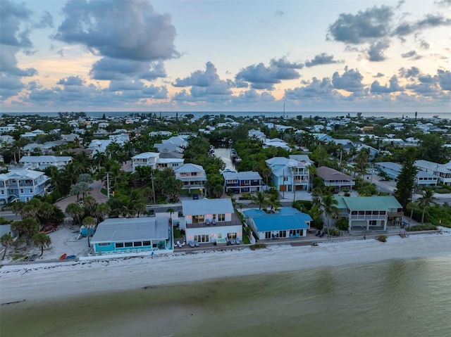 aerial view at dusk with a beach view and a water view