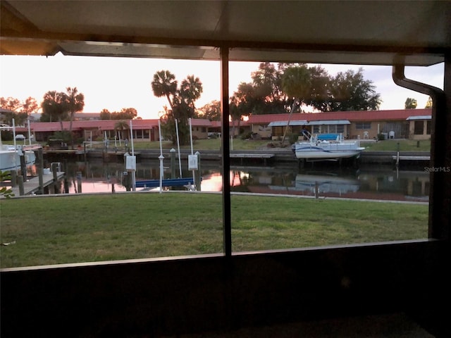 dock area with a lawn and a water view