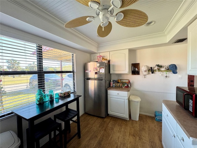 kitchen featuring wood walls, white cabinets, dark hardwood / wood-style floors, ornamental molding, and stainless steel refrigerator