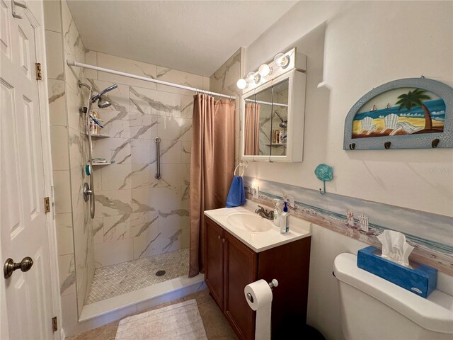 bathroom with tile patterned flooring, a shower with curtain, vanity, and toilet