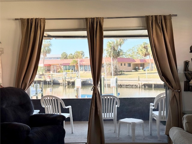 sitting room featuring carpet, a water view, and plenty of natural light